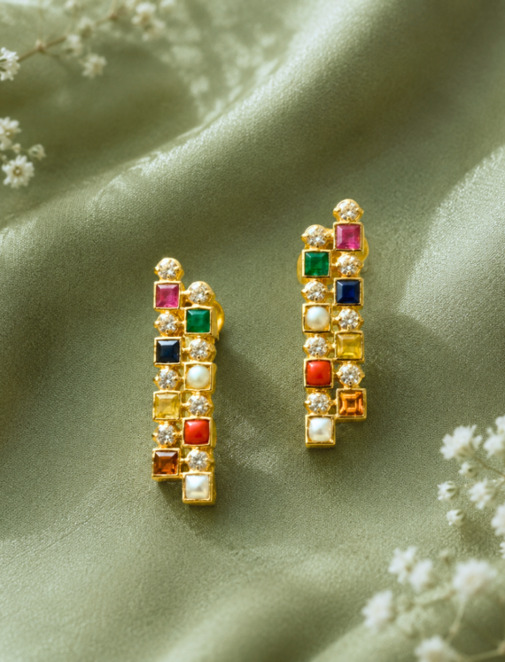 Gold earrings with square multicolor gems and small diamonds on a green satin background, elegant and sparkling.