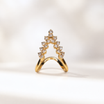 Gold ring with a slender curved band and a diamond-encrusted triangular arch forming a peak at the top.