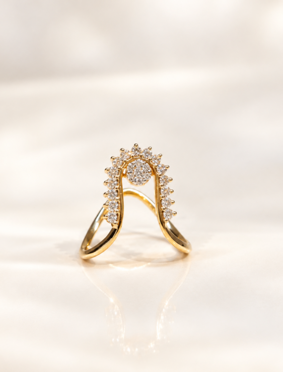 Gold ring with a curved halo setting studded with diamonds, resting on a reflective surface.